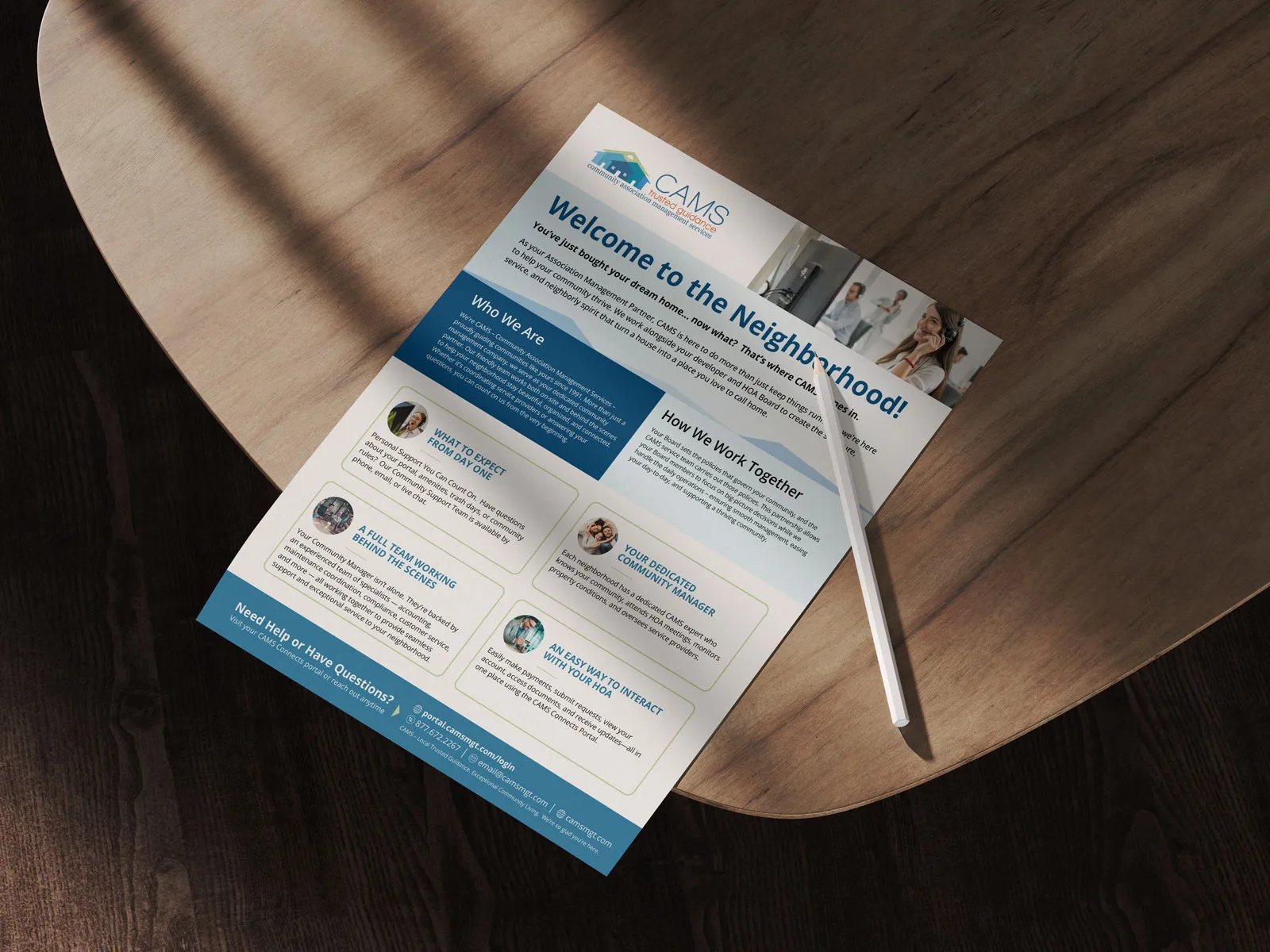 CAMS "Welcome to the Neighborhood!" flyer lying on a wooden table with a pen, showing who CAMS is and how they work with communities.