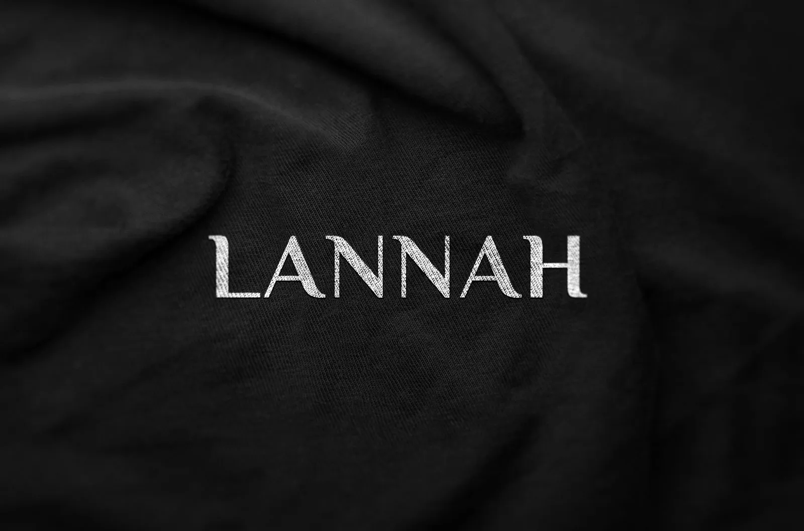 Lannah wordmark embossed on black fabric.