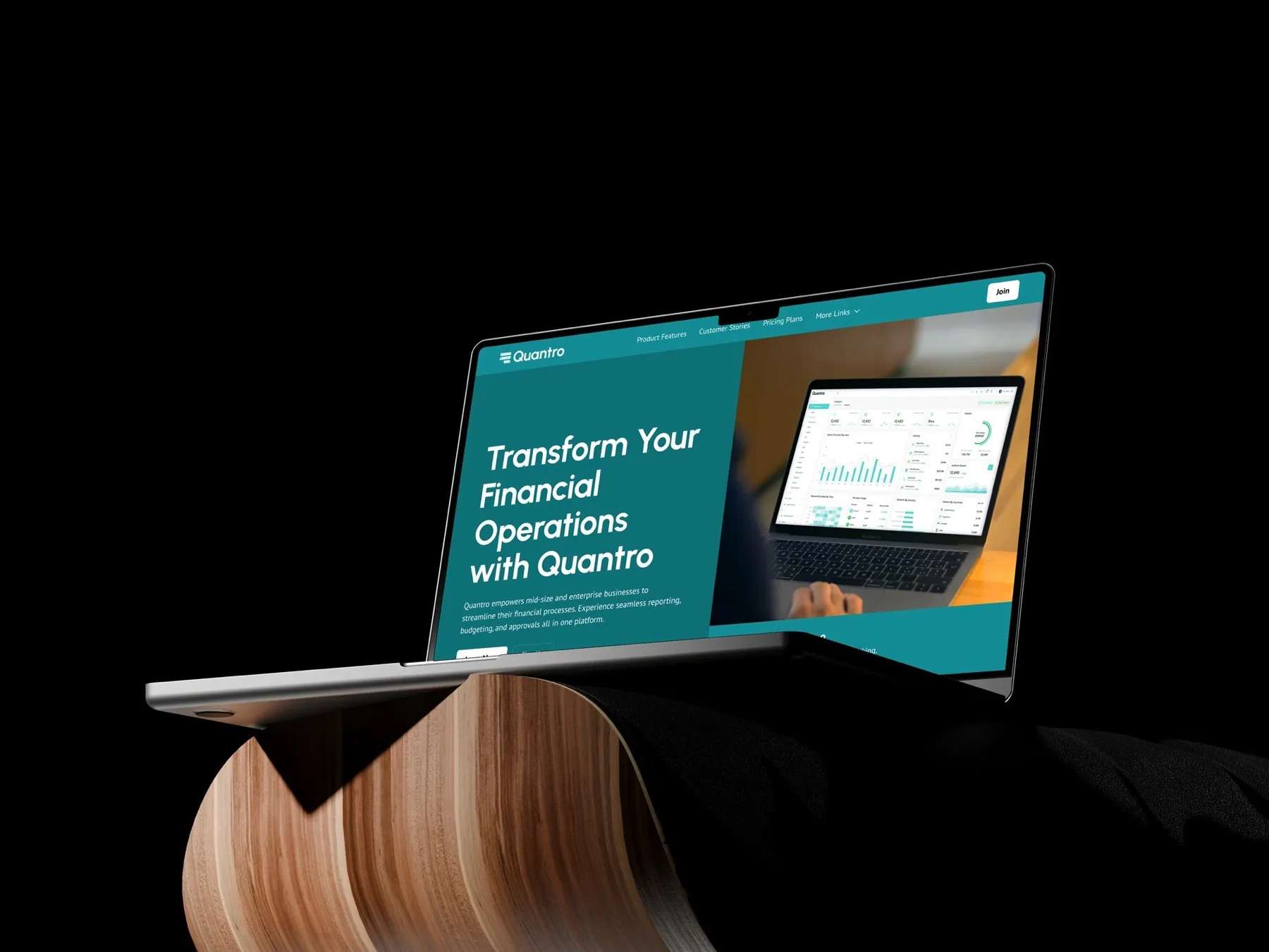 Laptop on a curved wooden stand showing the Quantro homepage: "Transform your financial operations with Quantro".