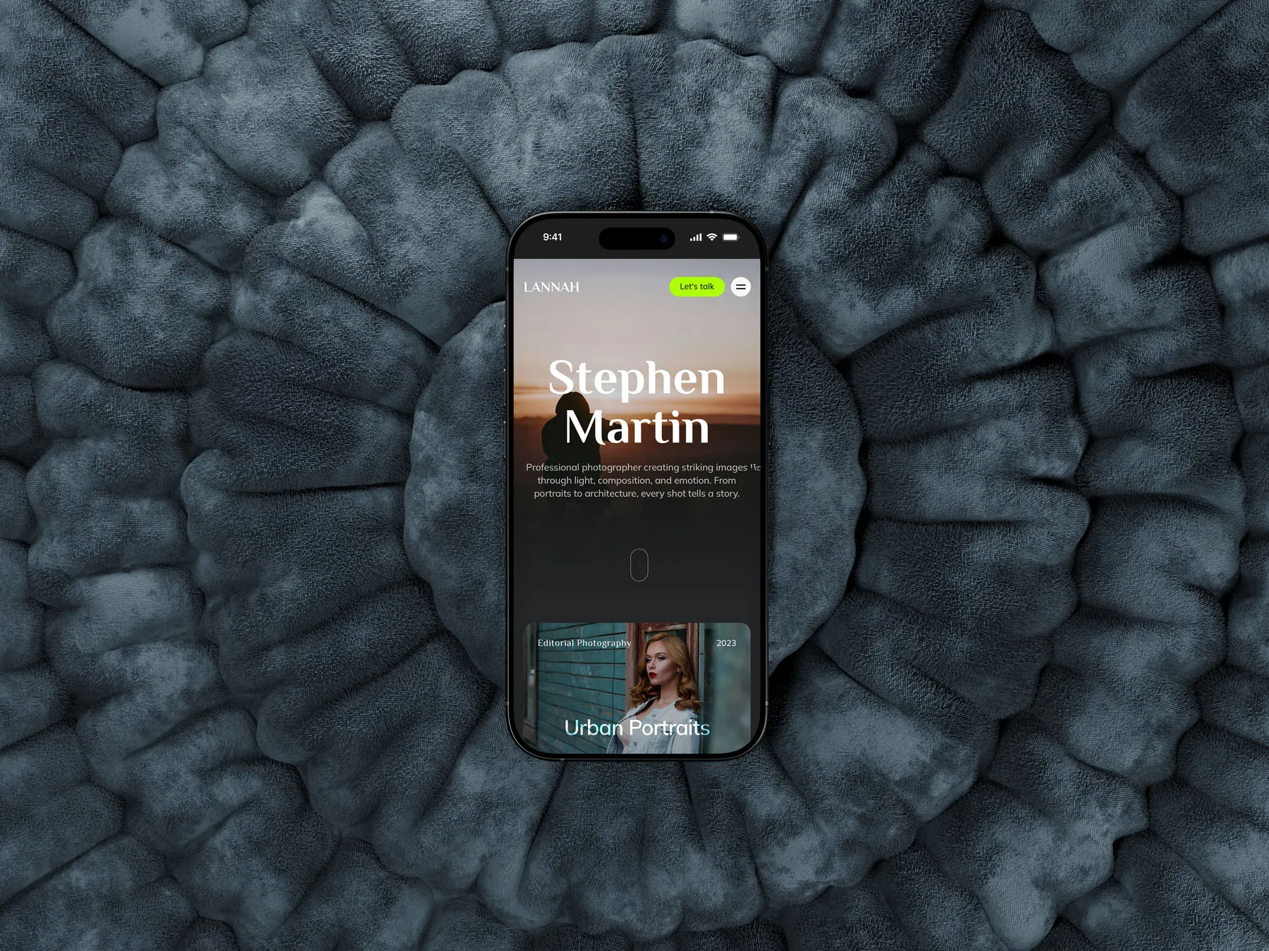 Phone on a textured grey surface showing the Stephen Martin photography homepage built on the Lannah template.