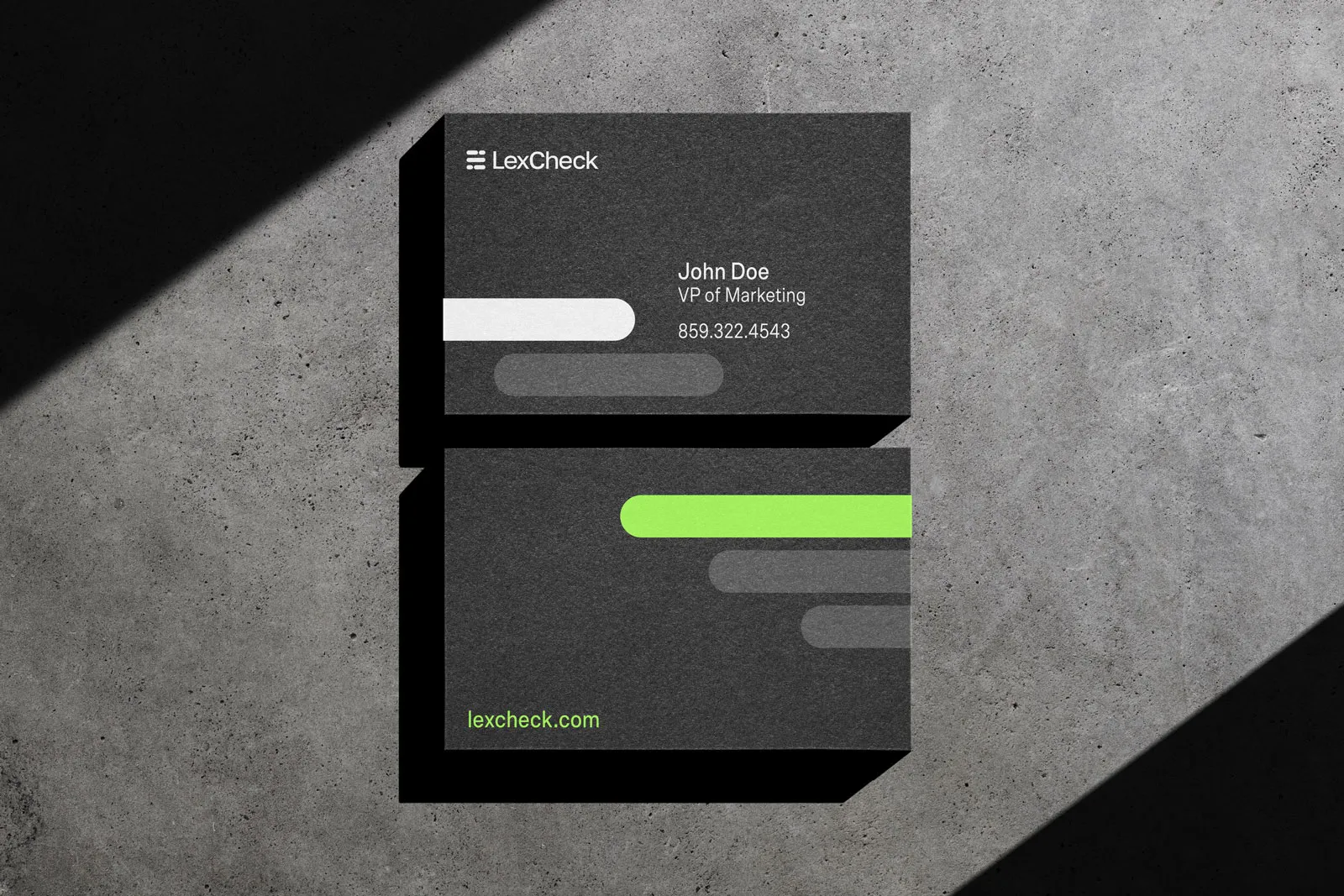 LexCheck business cards in dark grey with lime accents on a concrete surface.