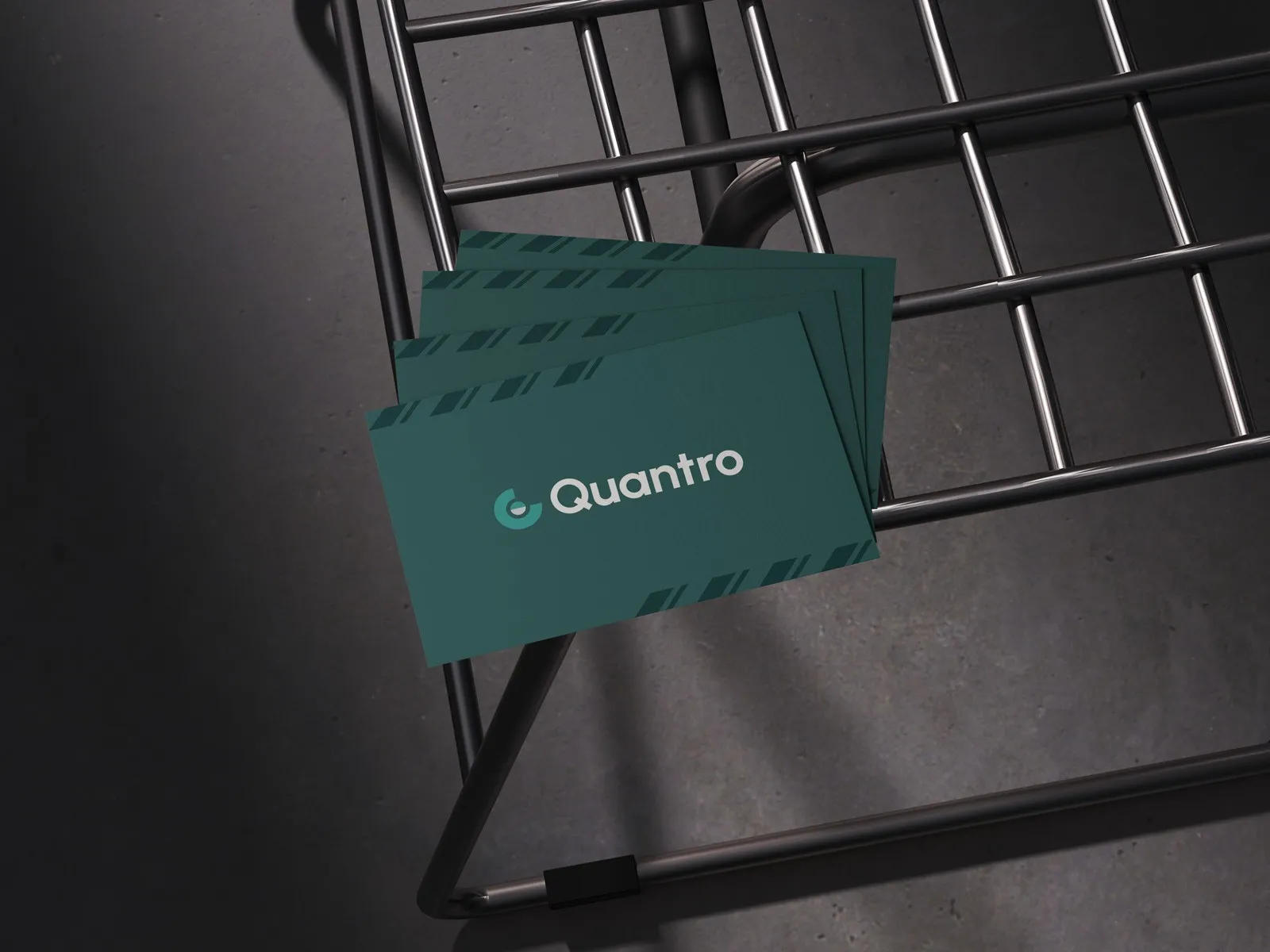 Quantro-branded dark green cards resting on a black wire chair.