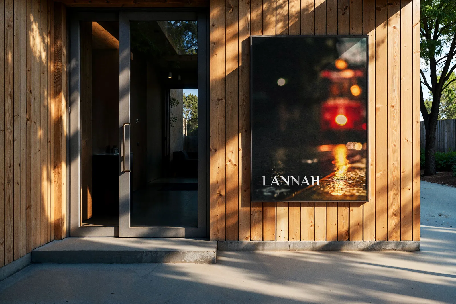Framed Lannah poster on a wooden building beside a glass door.
