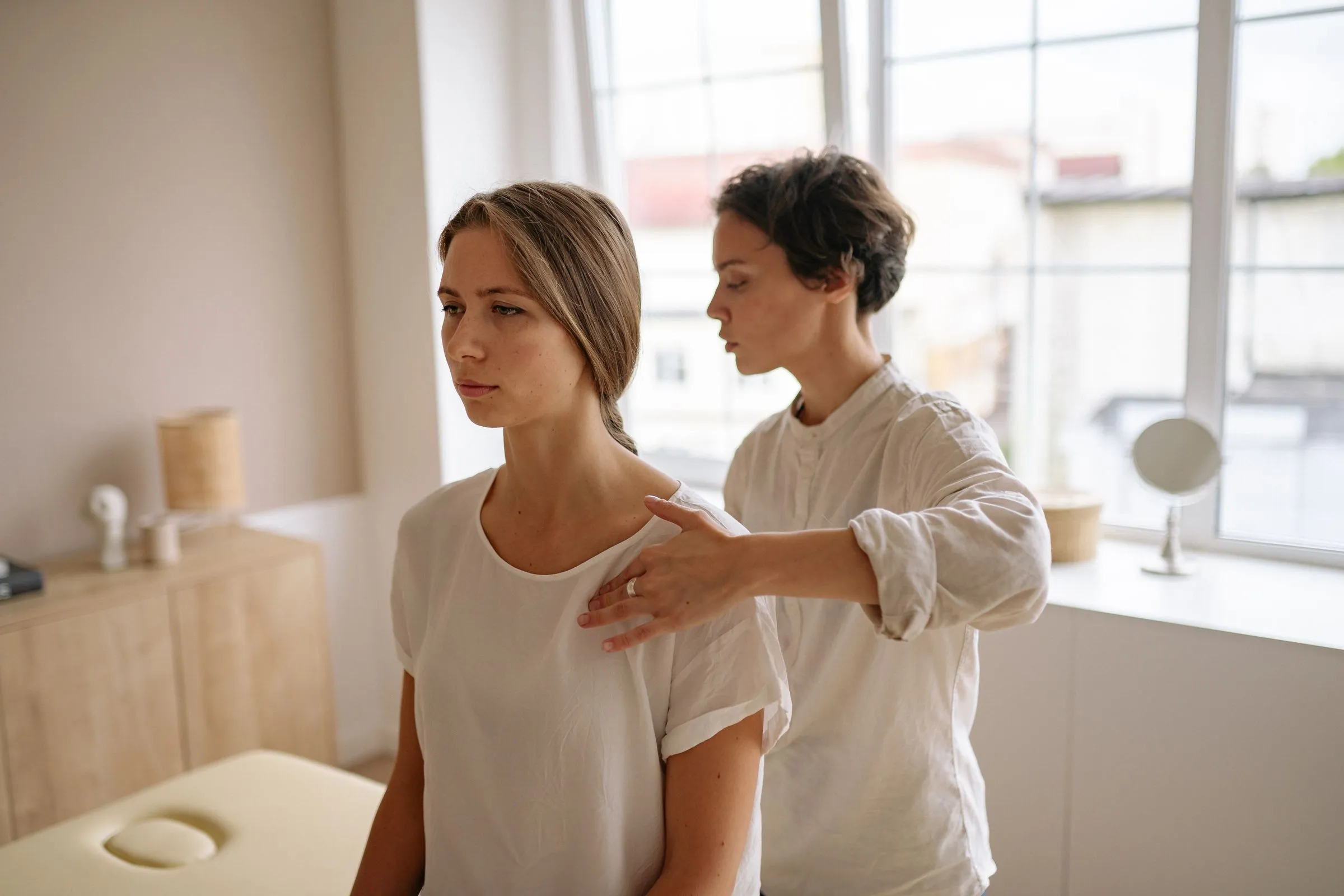 The doctor talking with a new patient, a hand on her shoulder.