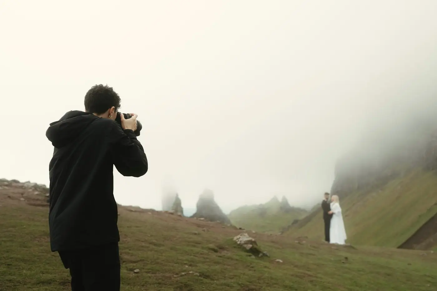 Stephen photographing a bride and groom on a foggy green hillside on the Isle of Skye