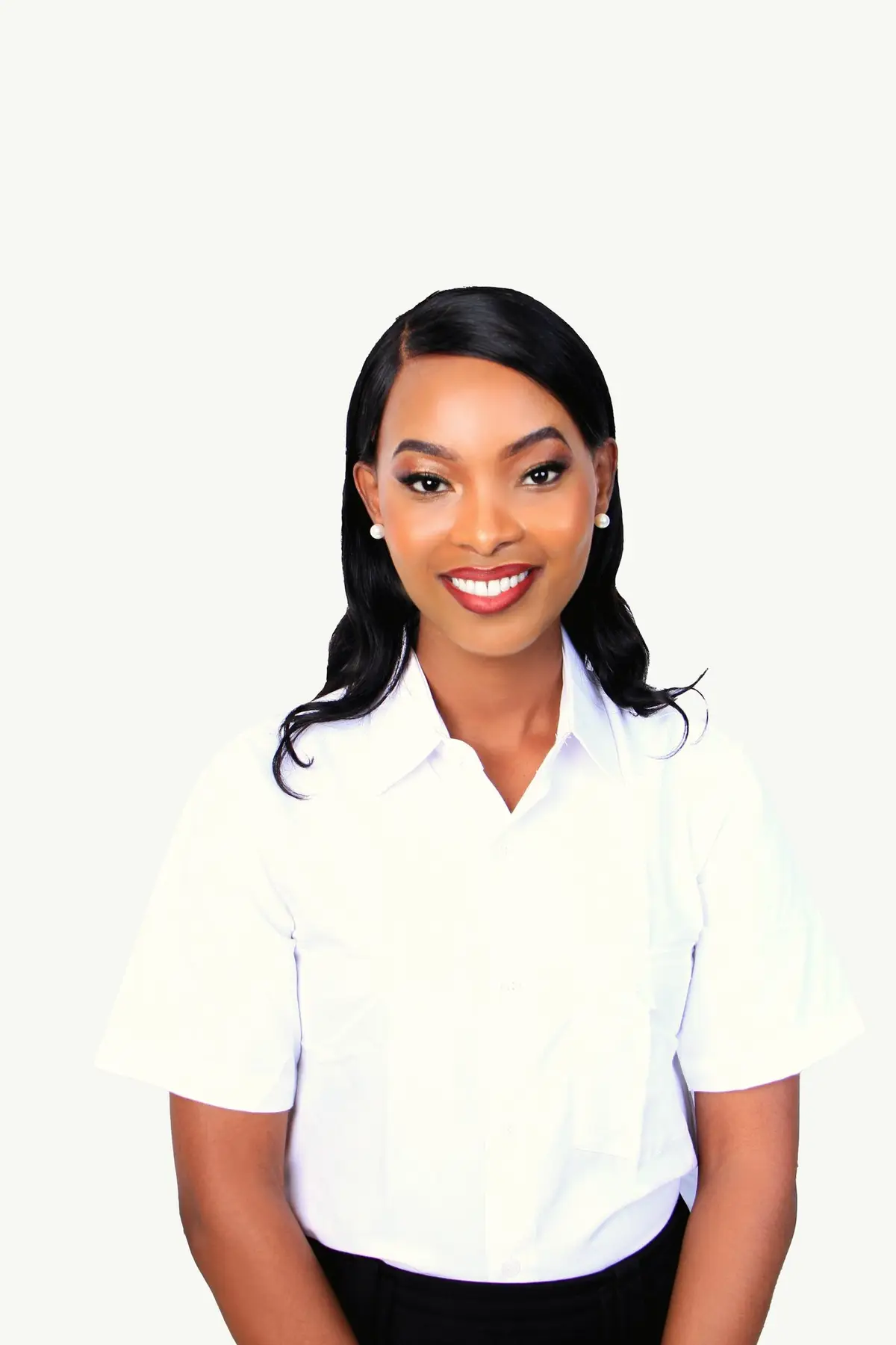 Portrait of Alicia Moore smiling, in a white collared shirt against a light background.