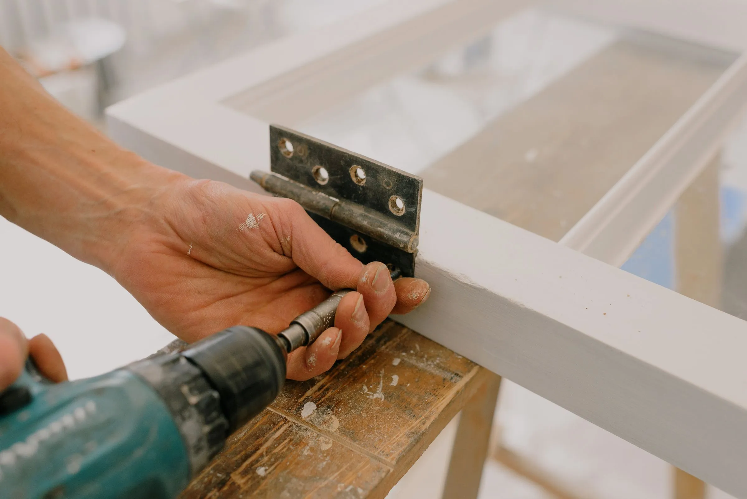 Installing a cabinet hinge with a drill.