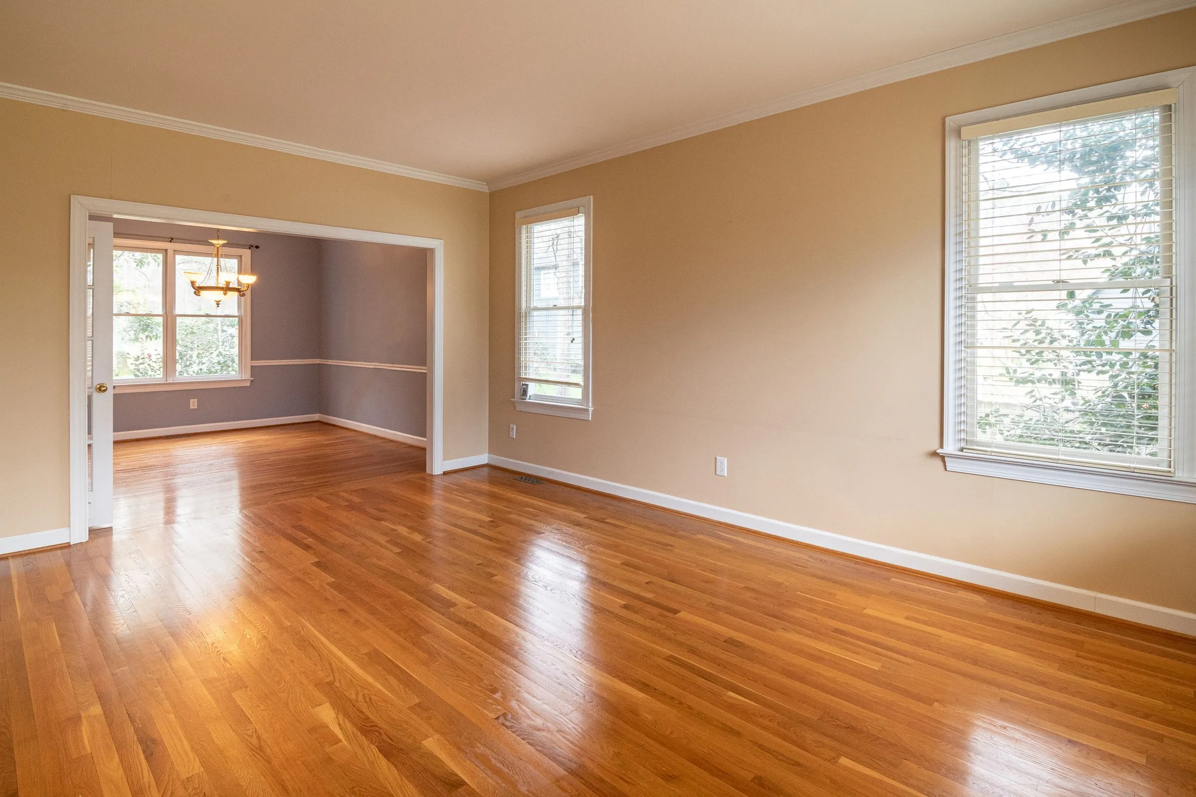 An empty room with new hardwood floors and fresh paint.