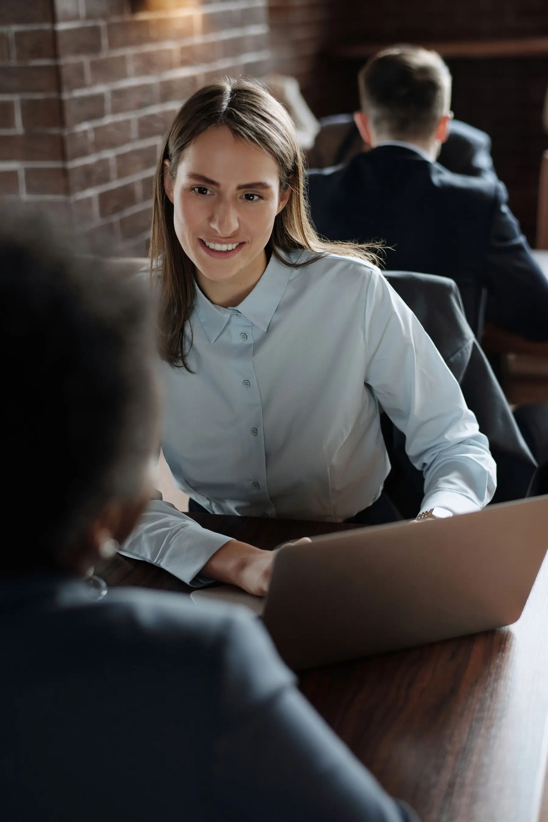 A Quantro advisor smiling as she walks a client through their numbers at her desk