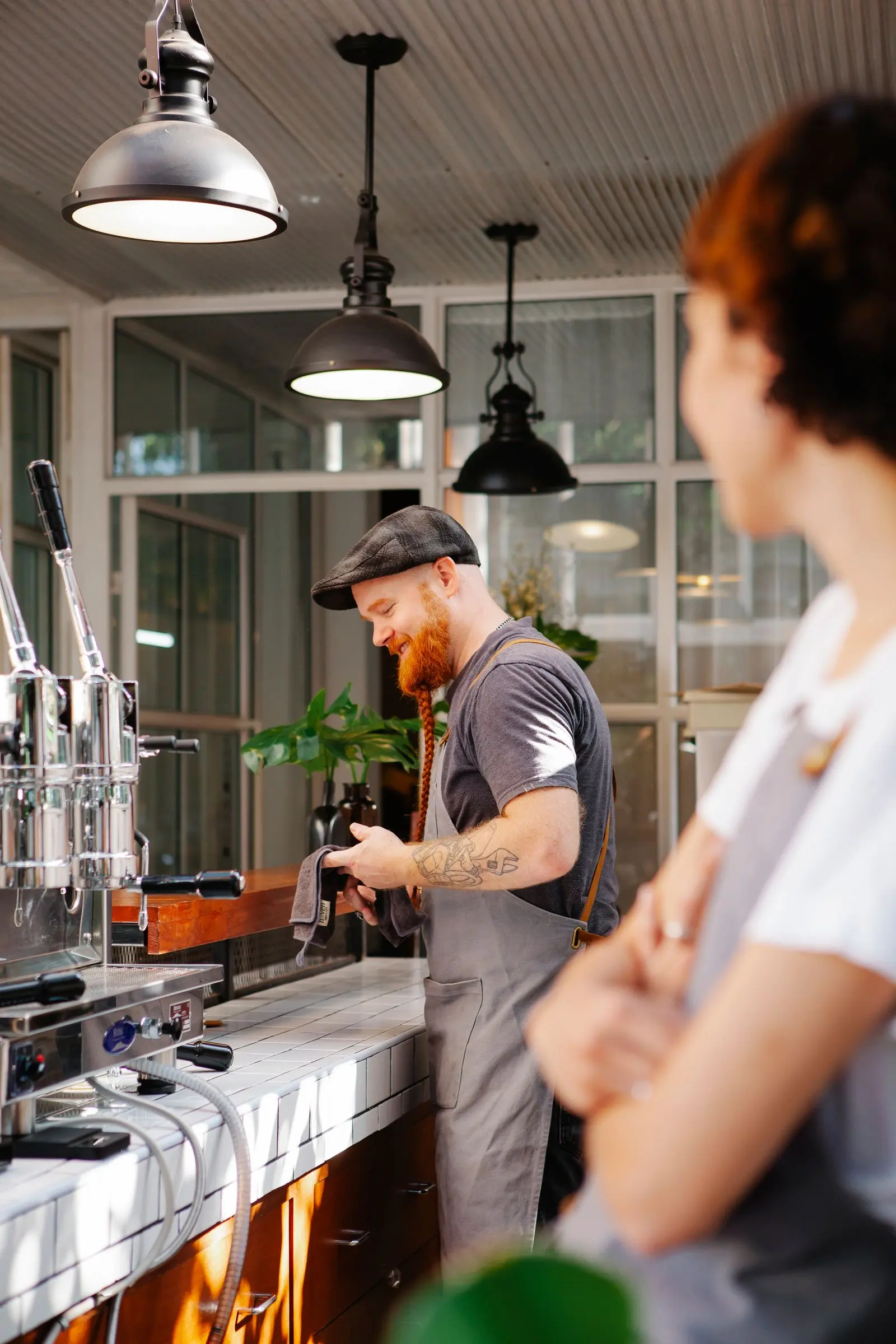 A barista making coffee behind the counter at one of Ember’s cafés