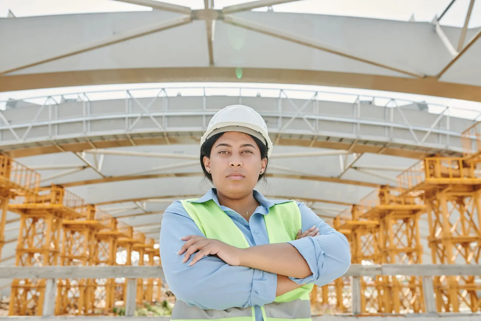 A site supervisor in a hard hat and safety vest standing at a construction site