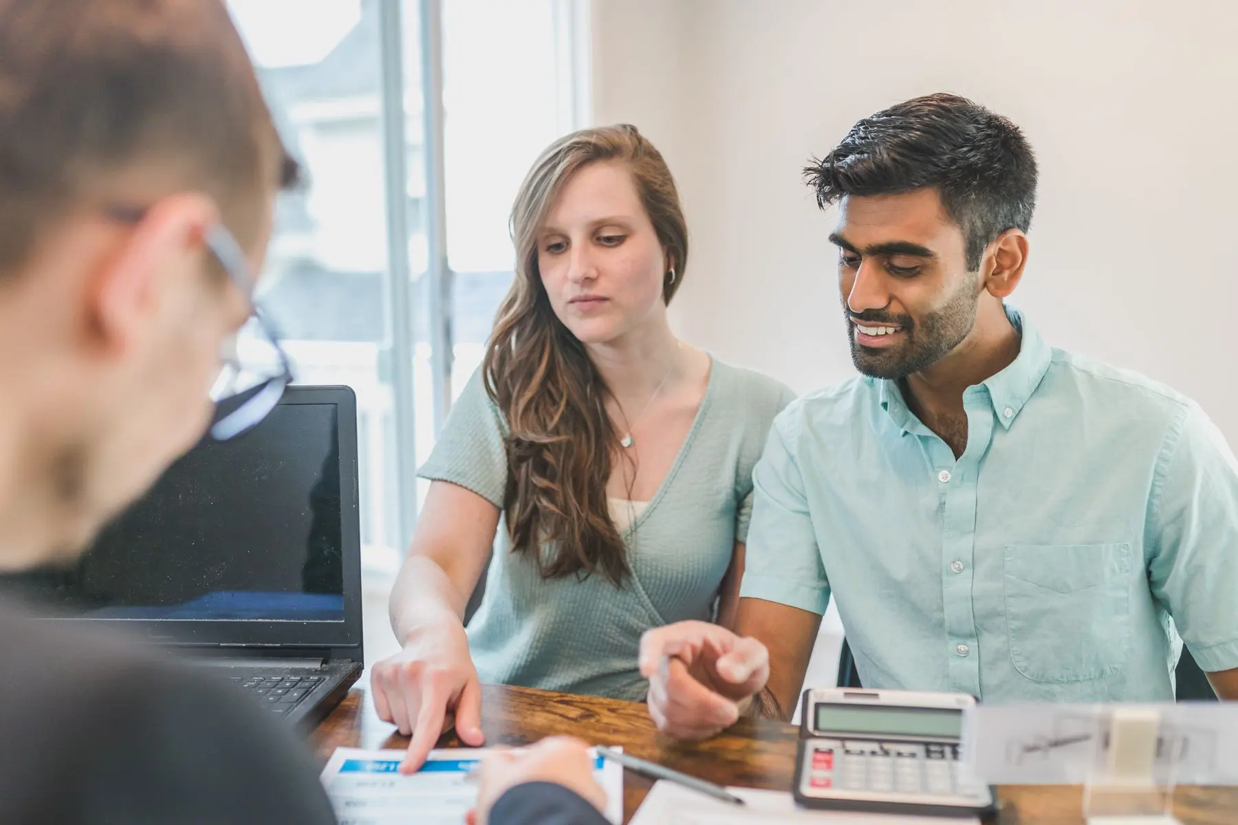 A young couple reviewing their tax return with an advisor